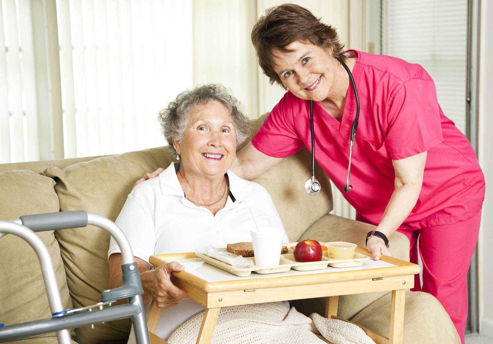 Friendly nurse brings a mean to an elderly shut-in.  Could also be lunch time at the nursing home.