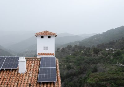 Sustainable living in a fog-covered mountain village, with solar panels on terracotta rooftops